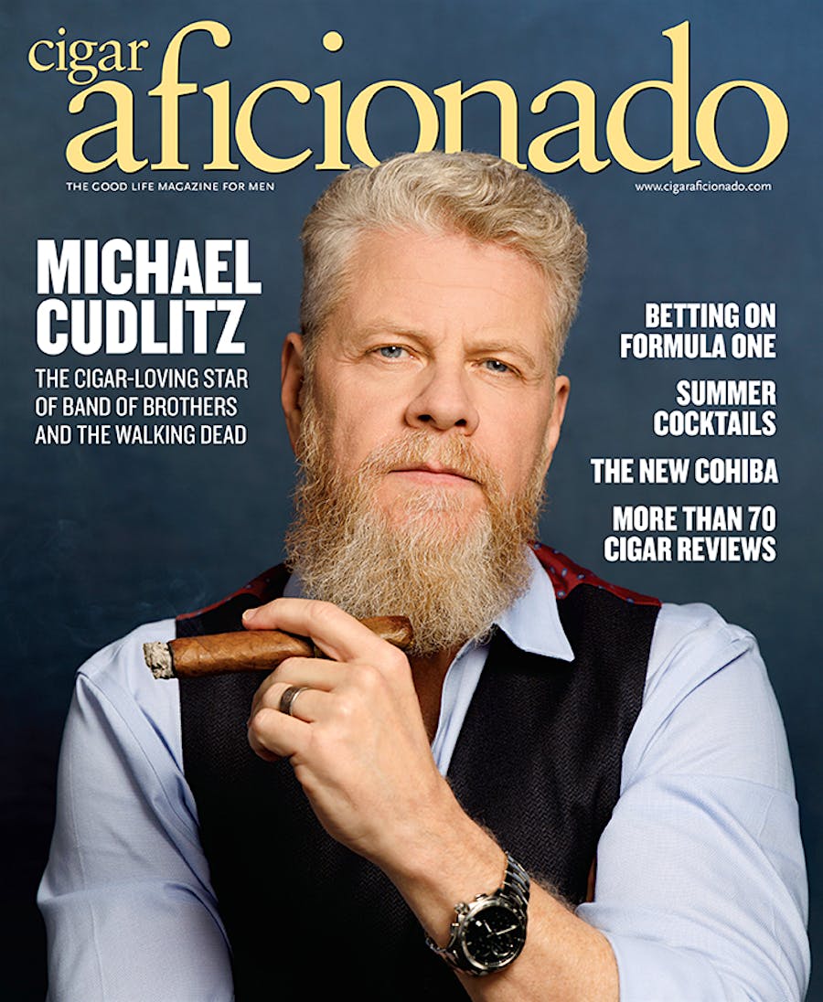 Magazine cover featuring a man with a beard holding a cigar, titled 'Cigar Aficionado'.