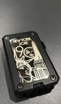Black and gold lighter with 'New York 2018' design on a gray background